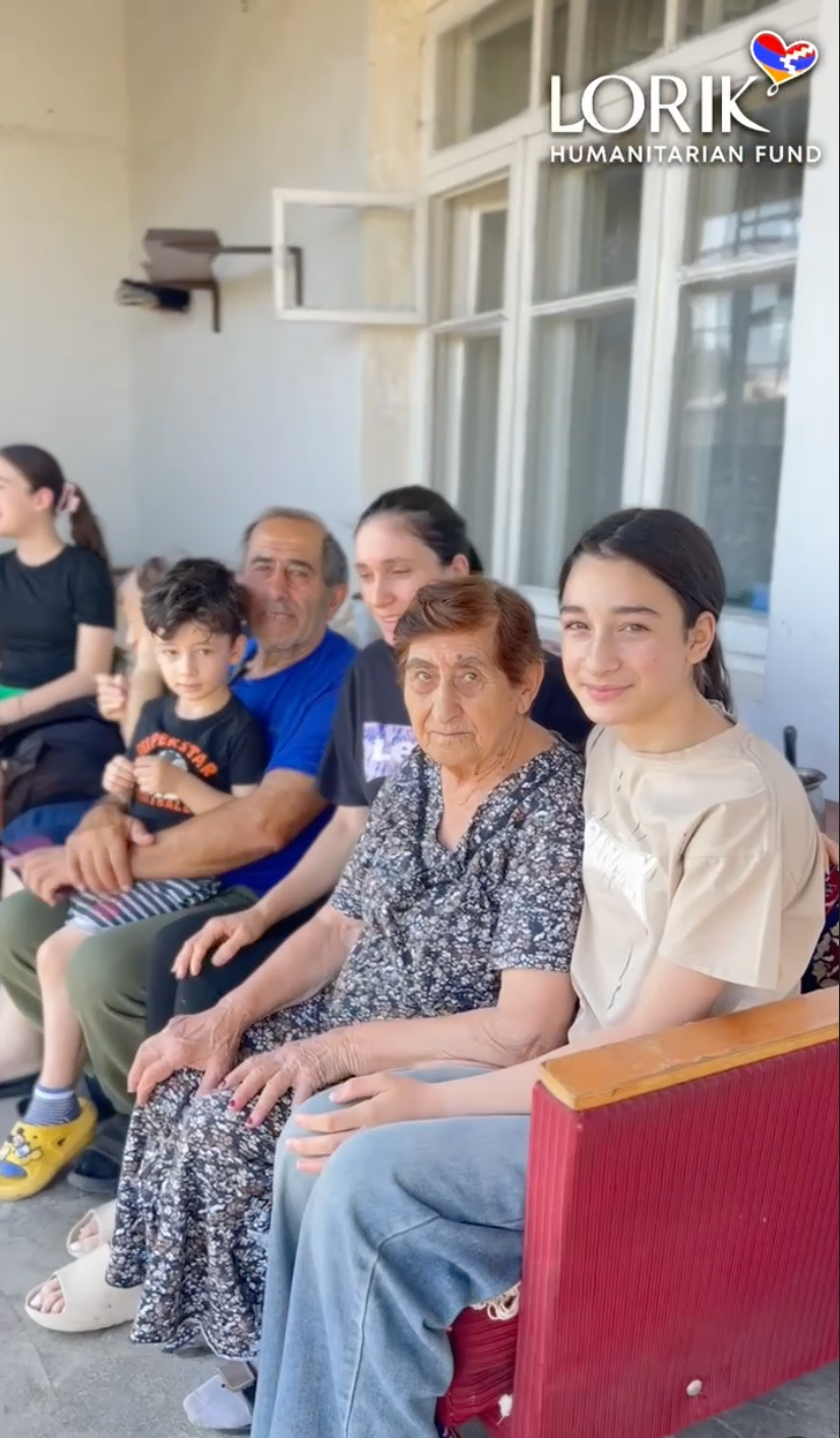 A family displaced from Artsakh caring for chickens provided through a Lorik Humanitarian Fund Small Business Development Grant.