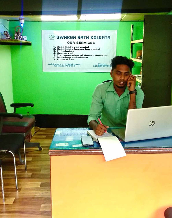 Swarga Rath Kolkata office with staff member providing funeral service assistance.