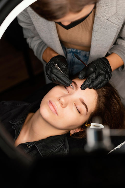 top-view-female-clinician-doing-eyebrow-treatment-woman.jpg