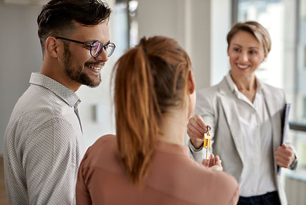 young-happy-couple-buying-new-home-receiving-key-from-their-real-estate-agent.jpg