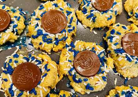 Gluten-free thumbprint cookies filled with chocolate gelt and decorated with colorful sprinkles.