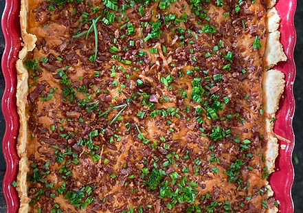 Close-up of a golden-brown gluten-free potato pie with chives topping it.