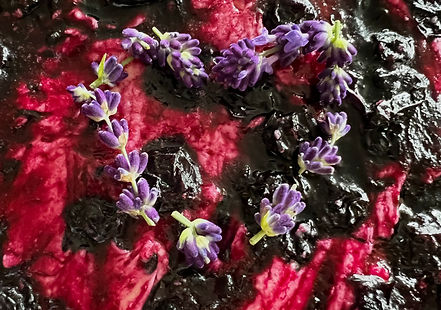 "A jar of homemade blueberry lavender lemon jam with a deep purple color, showing whole blueberries and a slightly chunky texture.