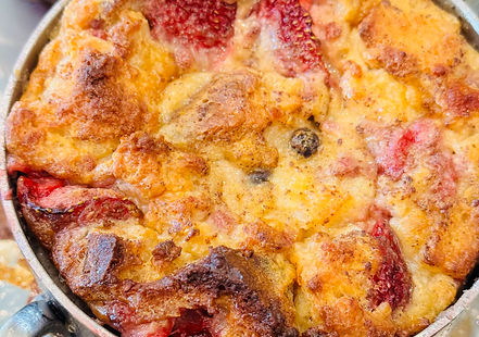 Warm, custardy gluten-free bread pudding with a slightly crispy top, studded with an assortment of colorful berries.