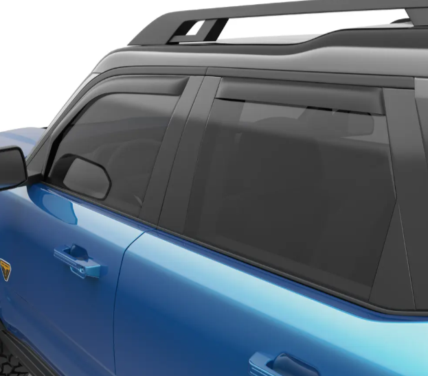 Blue SUV with dark tinted windows and a roof rack, parked. A small emblem is on the door. The setting is neutral, with no background.