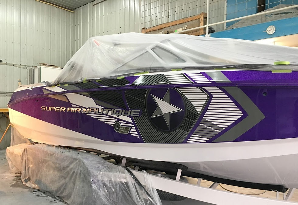 Purple and white boat with "Super Air Nautique G25" text, covered in plastic, in a warehouse. Bold star design on the side.