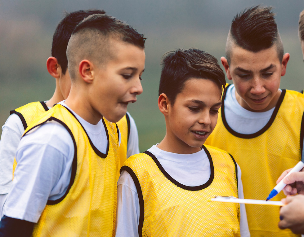 Youth Footballers Listening To Football Coach Instructions
