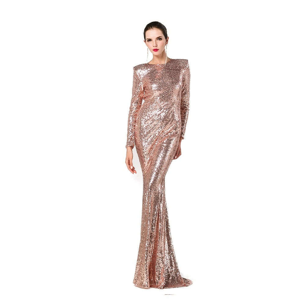 Elegant woman in a rose gold sequined gown, posing gracefully, on white background.
