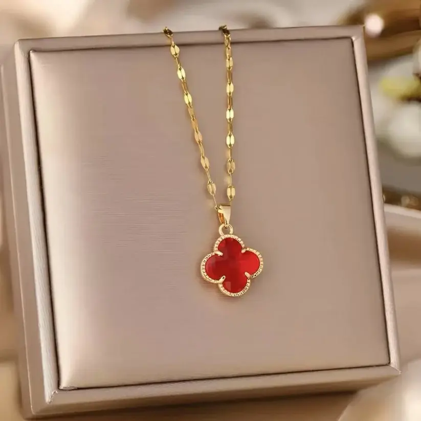 Ruby clover pendant necklace displayed on a jewelry box