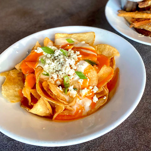 Doherty's Irish Pub & Restaurant Smothered Blue Buffalo Chips
House-cooked chips topped with gorgonzola cream, blue cheese crumble & green onion.  Finished with a drizzle of sweet red pepper jelly or spicy buffalo sauce.