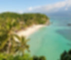 Tropical beach with palm trees, clear turquoise water, and swimmers. Green lush hills in the background under a clear blue sky. Relaxing mood.