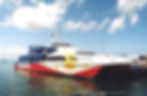 A catamaran Ferrie painted with Red, Blue, white and three stars and the sun in yellow the colors of the Philippine flag.