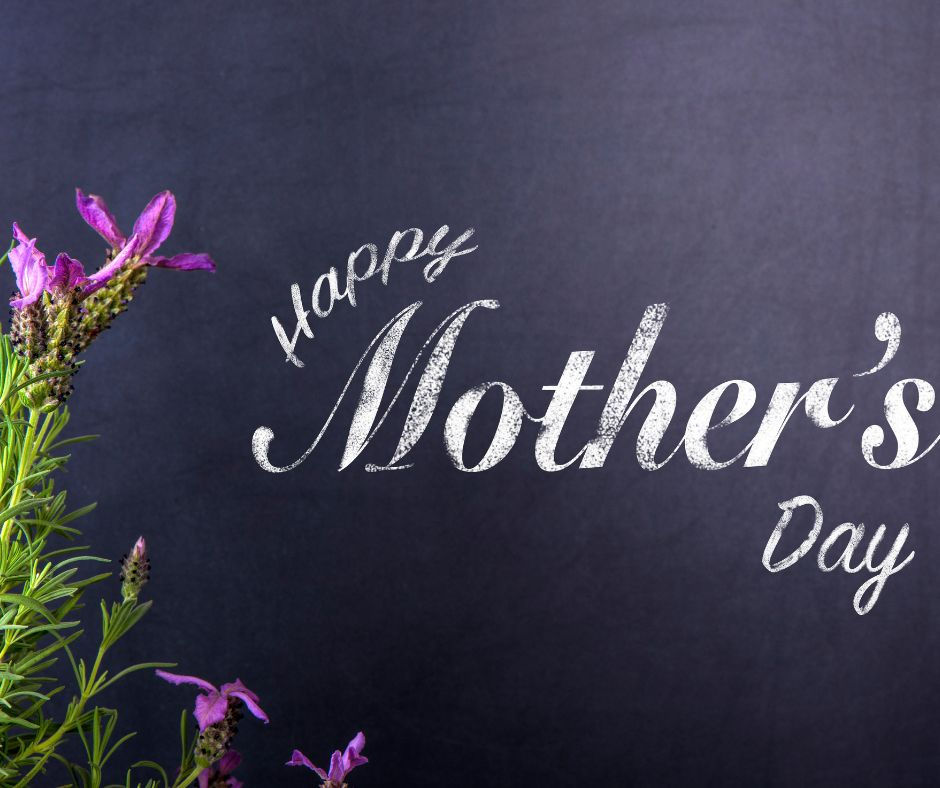 Purple wildflowers on the left, dark background. White text reads "Happy Mother's Day." Elegant and celebratory mood.