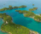Hundred Islands National Park Aerial view of lush, green islands and turquoise sea. A large statue is visible on one island. Clear skies, tranquil mood.