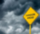Yellow "Typhoon Ahead" sign against dark, ominous storm clouds, conveying a warning and tense atmosphere.