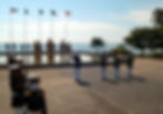 Looking at soldiers in their dark blue and white uniform in a ceremony in the memorial statues in clear light blue sky.