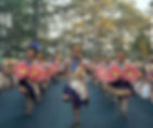 Panagbenga - Flower Festival Baguio City, colorful dancers in traditional attire parade with large pink flowers on a tree-lined street, exuding joy and celebration.