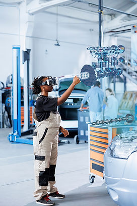Qualified engineer in repair shop using VR googles and augmented reality hologram to visualize car parts in order to fix them. BIPOC woman using AR technology while working on damaged vehicle motor
By DC Studio