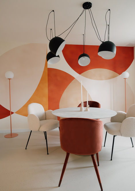 Elegantes Wohnzimmer mit schönen Farbakzenten und einem Tisch mit Stühlen sowie Lampen