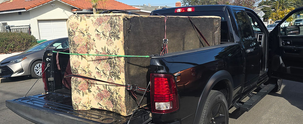 Old couch strapped in back of pickup truck in San Diego