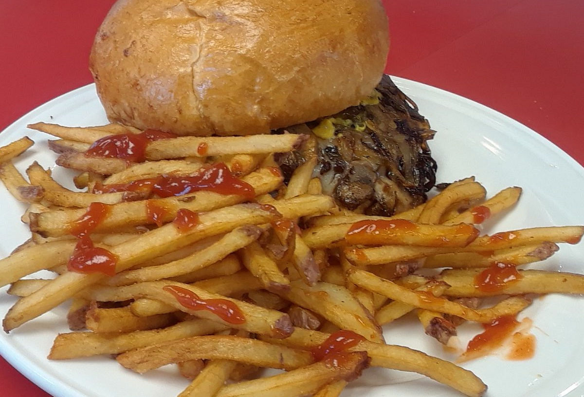 Signature Sloppy Bro burger with special sauce, cheese, onions, and fries on a plate from Band Box Diner in Minneapolis, Minnesota