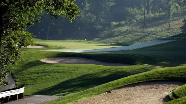 Scenic view of a signature hole at The Fort Golf Course featuring sculpted fairways, large sand bunkers, elevated greens, and dense mature trees creating a classic parkland challenge.