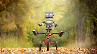 Happy humanoid robot rides a bicycle alo
