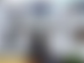 White historic building entrance with hanging baskets and lanterns. A sign reads "Dockray Hall historic pub & dining." Cozy and inviting.