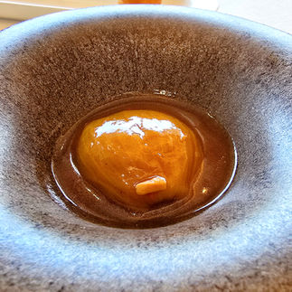 Onion stuffed with stewed meat, served on a dark plate.