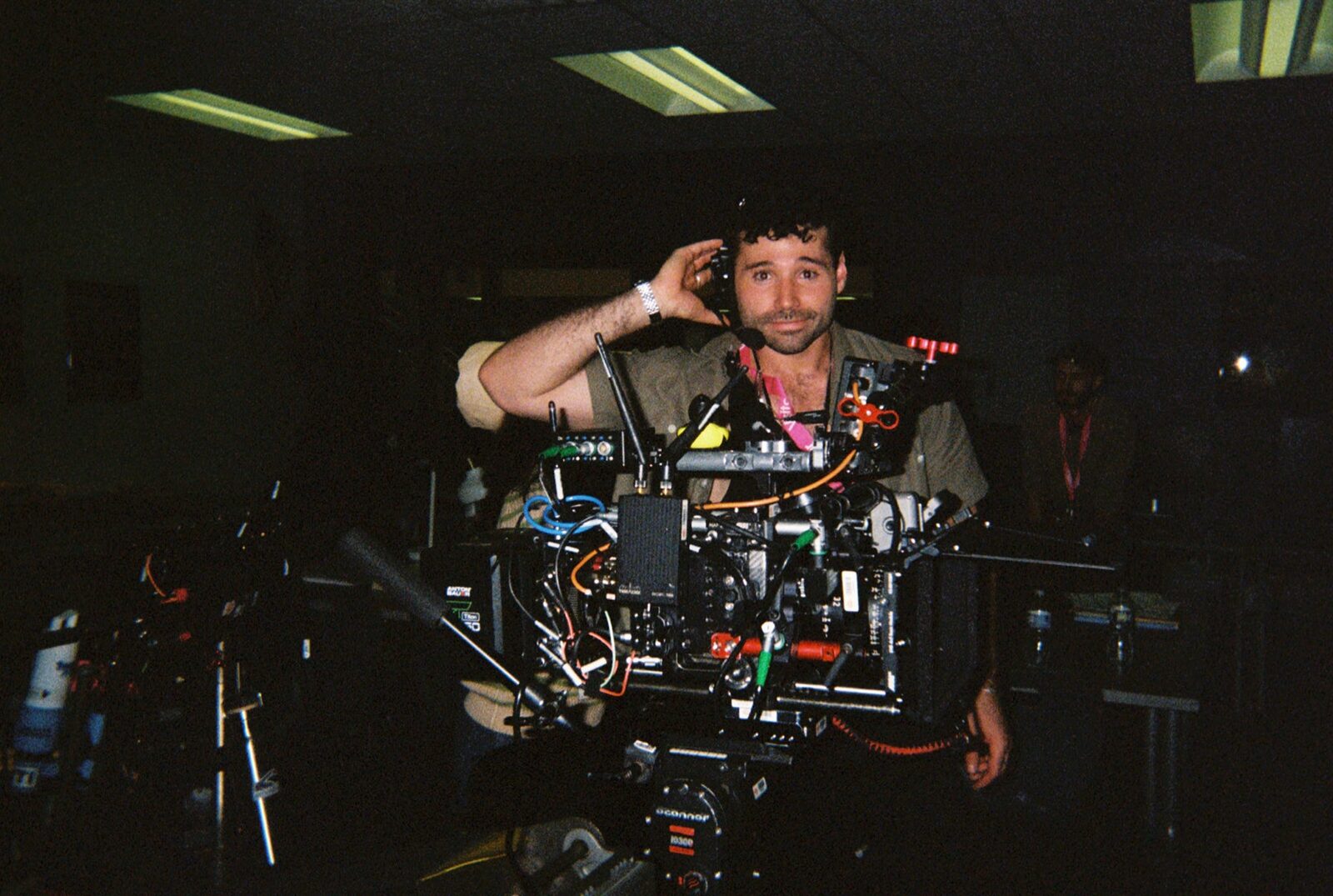 Elias Ginsberg behind the camera on set, headset on, grinning
