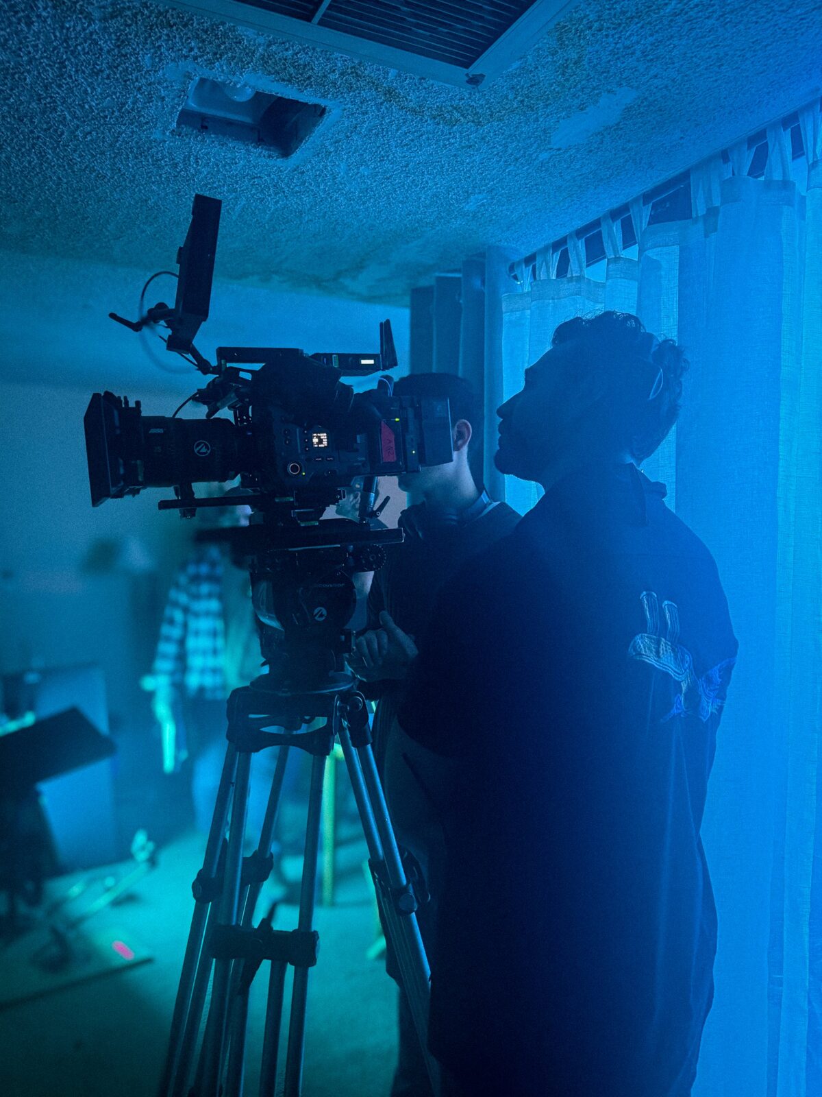 Elias at the eyepiece in blue light on the apartment set