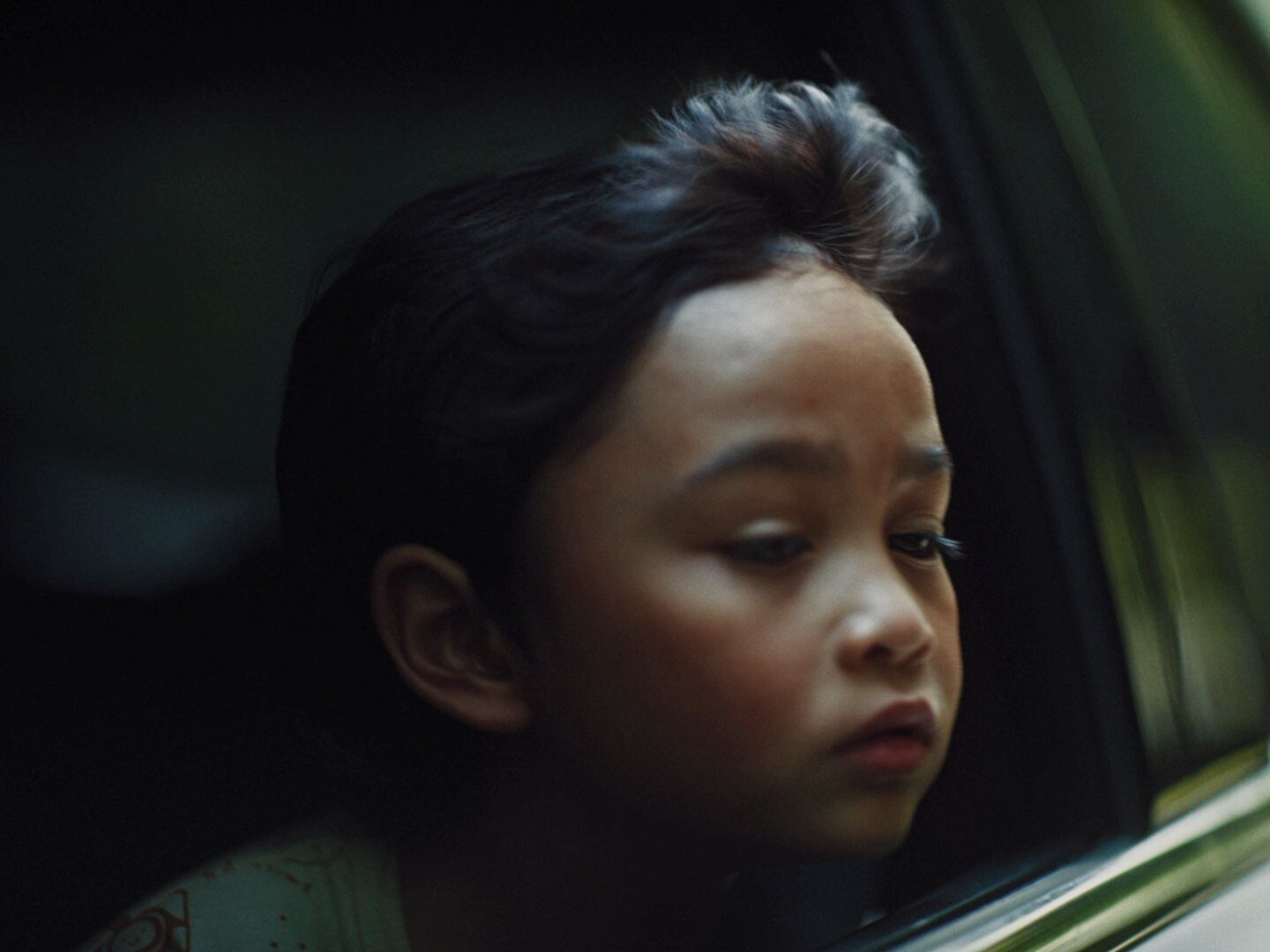 A child looks out of a car window