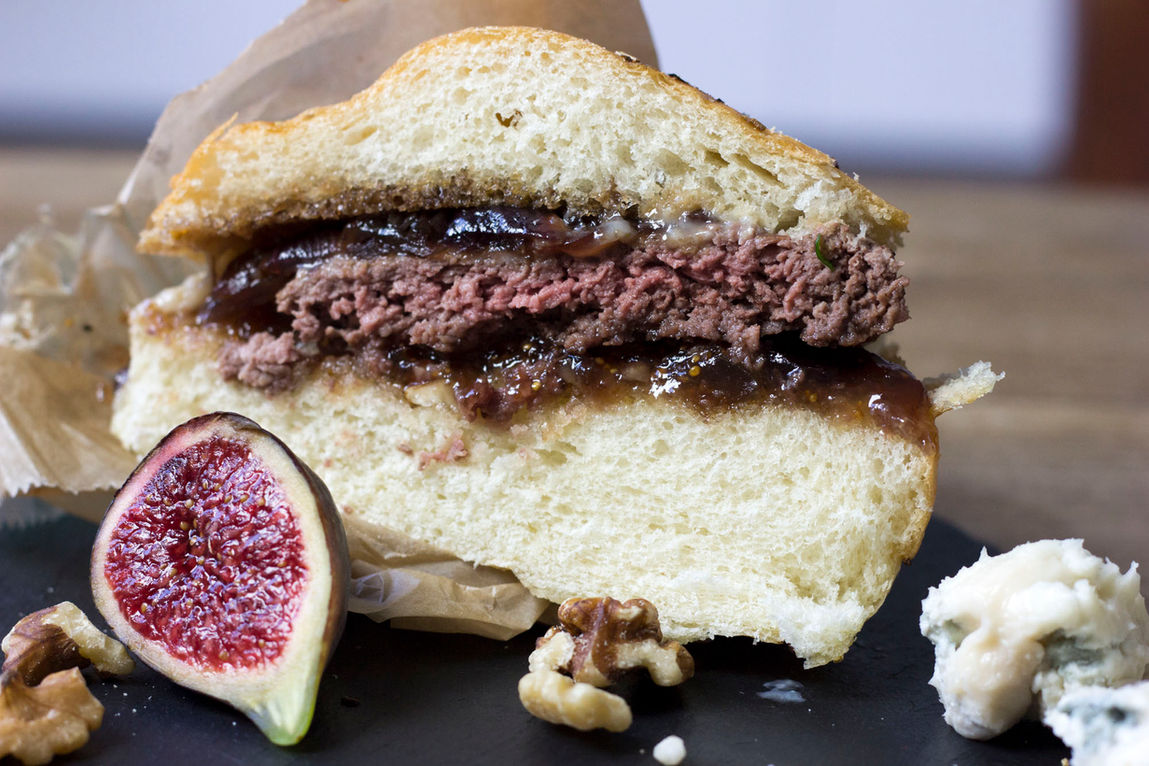 Photo mettant en avant une création culinaire alléchante spécialement conçues pour un foodtruck de burgers à l'inspiration italienne.