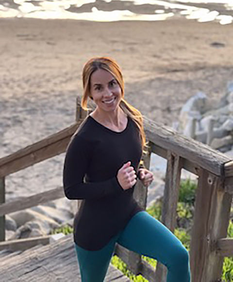 Sara Wright holding a dumbbell on the beach stairs in Santa Cruz, California