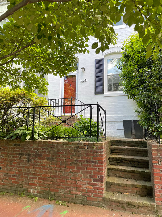 The sidewalk view with brick steps and retaining wall and side entry