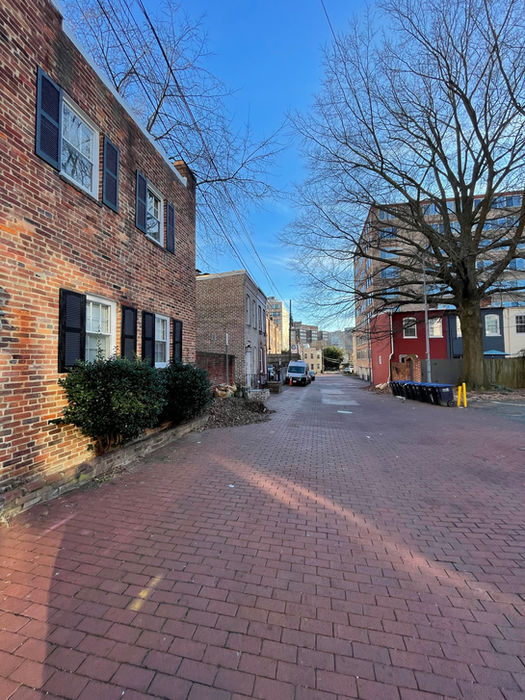 A long view of the red brick alley in the direction of I St in the distance. (D. Vogt, Dec. 2022)
