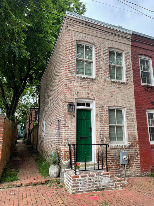 A side view of the house with a narrow brick foot path. (D. Vogt, Dec 2022)