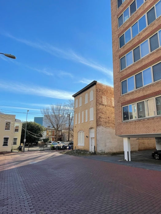 A view of Nash's Stable and rear of condo building (right) open parking lot area to I St (center) and historic rows (left). (D. Vogt, Dec. 2022)