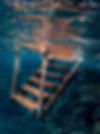 Rusted stairs underwater leading to surface