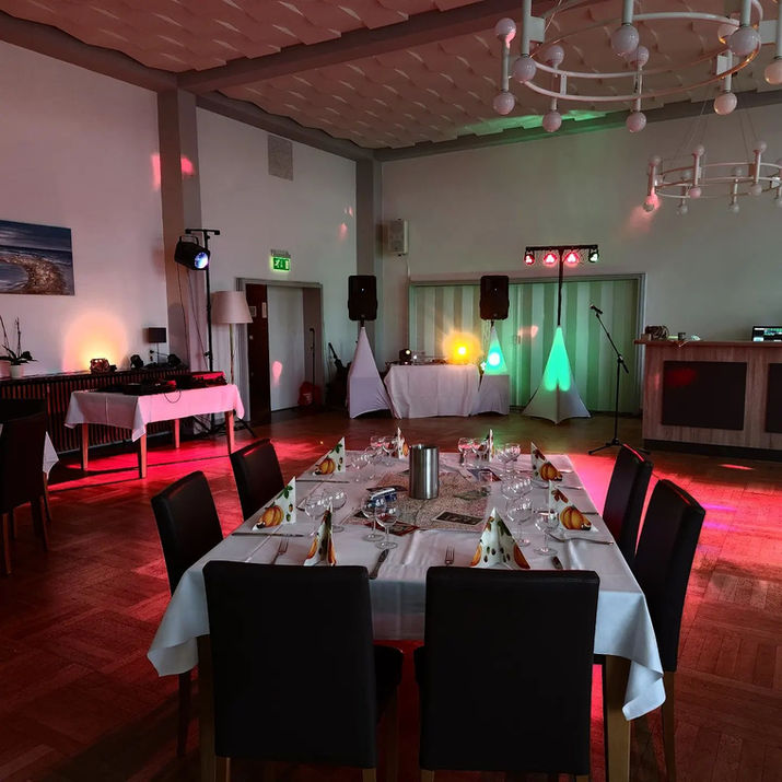 Festlich gedeckter Saal mit Ambientebeleuchtung für Veranstaltung