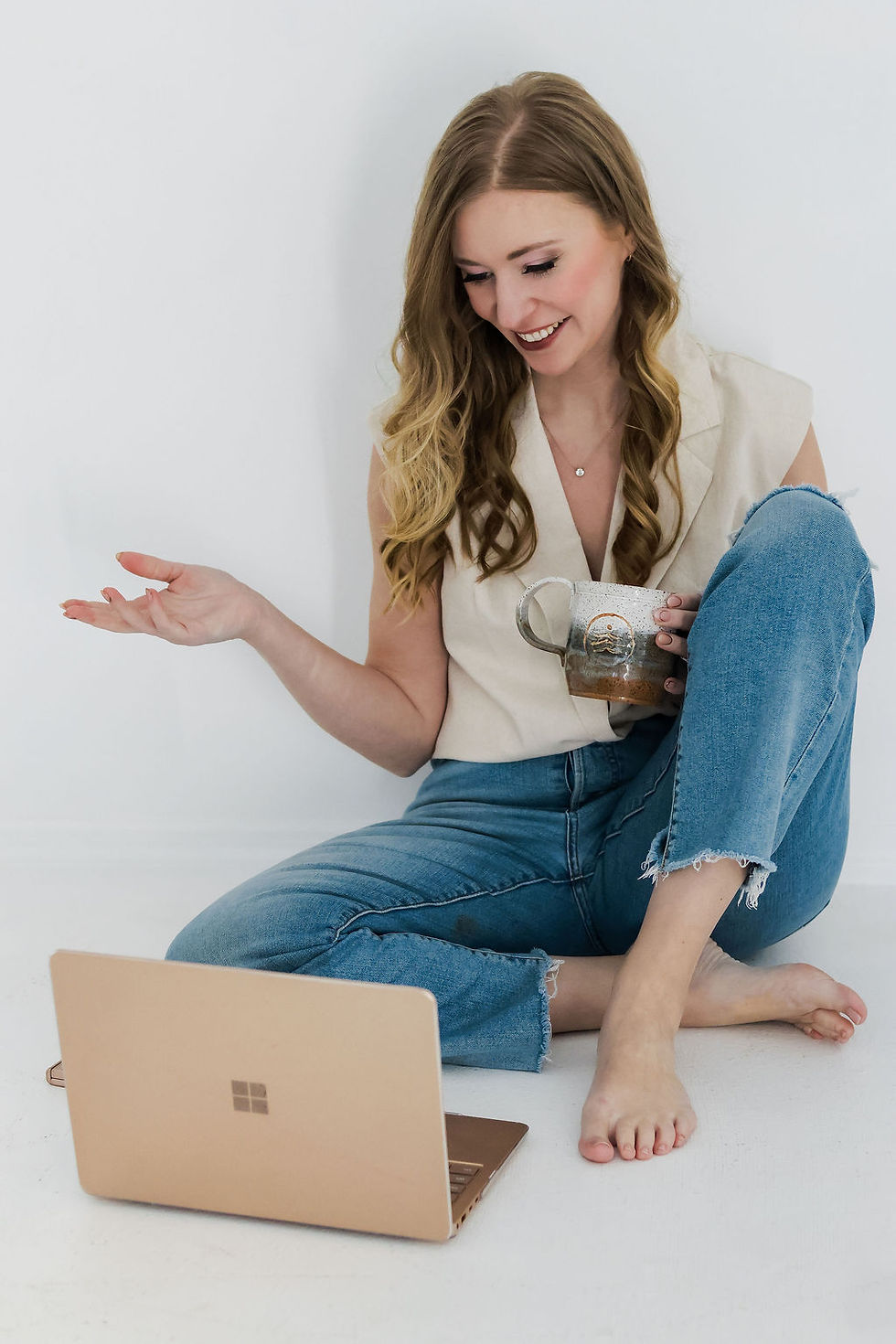 Woman seated on the floor using a laptop in a relaxed, informal workspace_