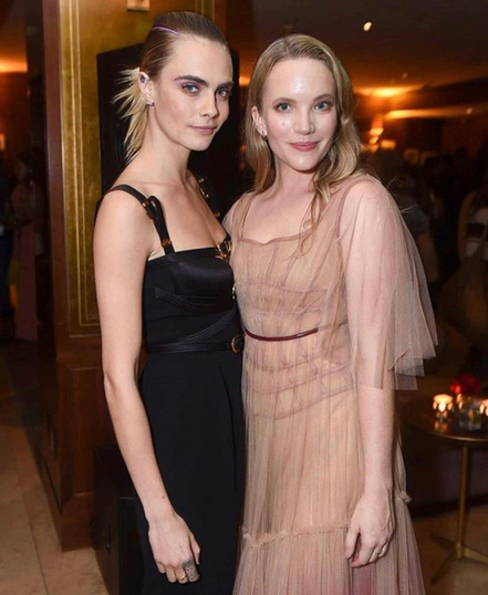 Actress Tamzin Merchant pictured with Cara Delevigne wearing pink tulle dress on the red carpet at Carnival Row Los Angeles film premiere, stylist Millie Cullum