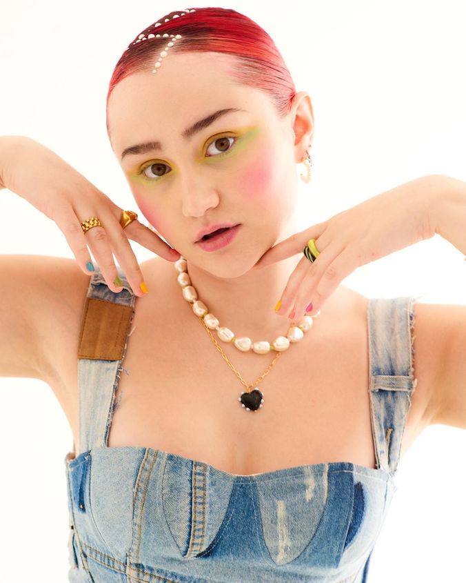 Singer and songwriter Madeleine The Person photographed in the studio wearing denim corset and pearl necklaces, stylist Millie Cullum
