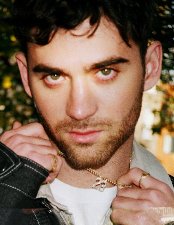 Portrait image of singer Alexander 23 photographed outside, stylist Millie Cullum