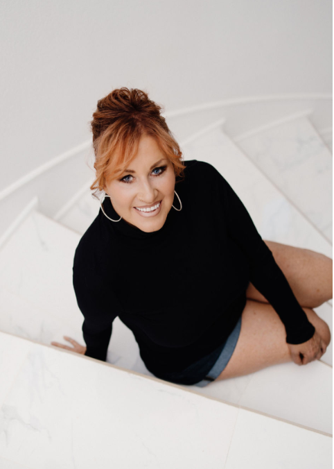 Kate Ouimette-Wedell headshot on a staircase