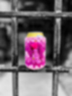 Pink crocheted drink coozie with heart button on yellow can, resting on weathered metal railing, b&w background"