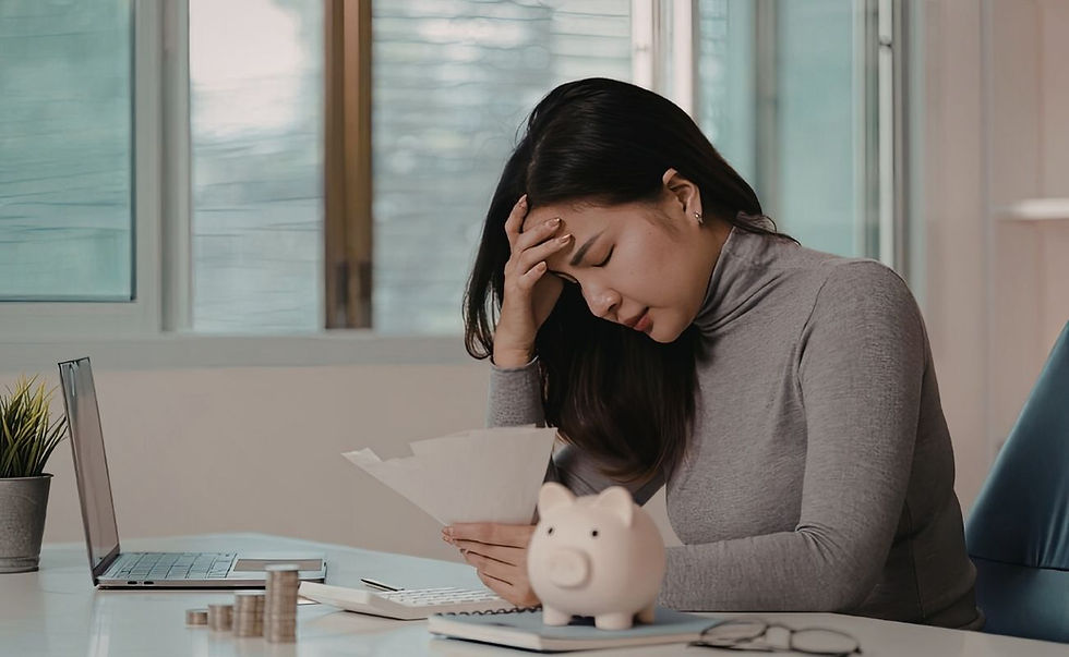 A person with their head in between their hands, elbows resting on the table.