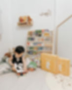 baby boy with his book shelf of storybooks and two josh and cherie book boxes