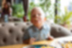 little boy with french fry in his mouth