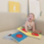 baby girl with board books and bright illustrations